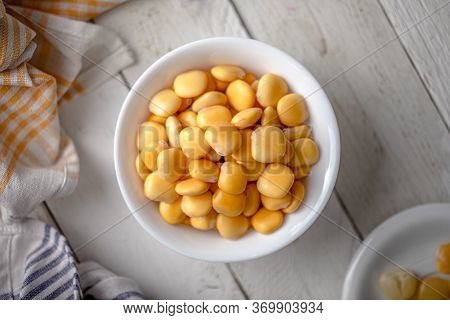 Lupins In A Bowl On A White Wooden Table With Napkins