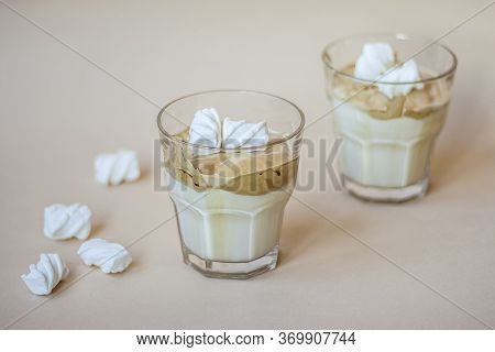 Dalgon Coffee In A Transparent Glass With Milk On A Pastel Background With Marshmallows.