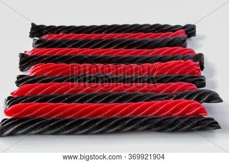 Alternating Red And Black Liquorice Candy Bars Laid Flat On White Background And Viewed From An Angl