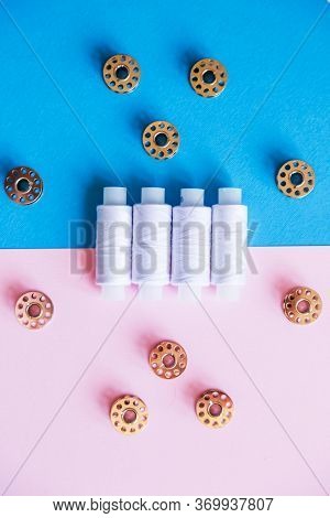 Row Of Whitethread Spools And Small Bobbins Of Thread Used In A Sewing Machine