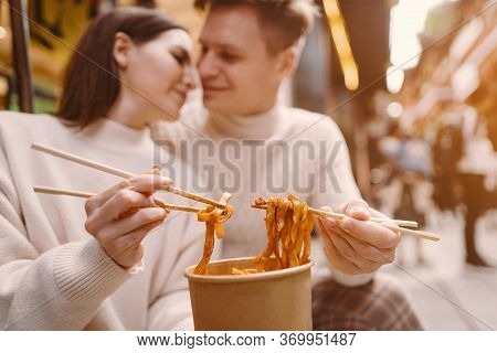 Newlywed Couple Eating Noodles With Chopsticks In Shanghai Outside A Food Market