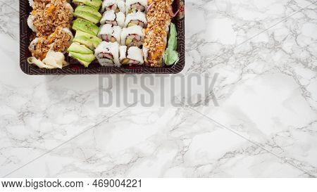 Flat Lay. Pre-packaged Variety Of Sushi And Sushi Rolls In A Plastic Tray.