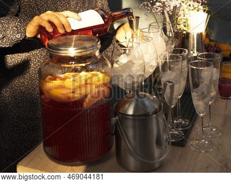 Glasses Of Cocktails On The Bar. Bartender Pours A Glass Of Sparkling Wine With Red Alcohol. Barman 