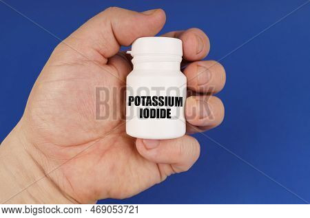 Pharmacology Concept. On A Blue Background In The Hands Of A Man Is A White Jar With The Inscription