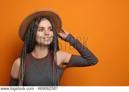 Beautiful Woman With Long African Braids And Hat On Orange Background, Space For Text