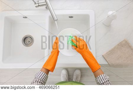 Woman Washing Plate Above Sink In Modern Kitchen, Top View