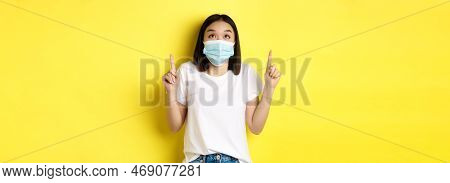Covid-19, Pandemic And Social Distancing Concept. Young Asian Woman In White T-shirt And Medical Mas
