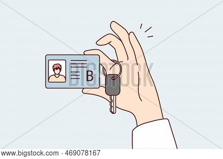 Category B Car License With Photo And Truck Ignition Key In Person Hand. Guy Boasts Of Drivers Docum
