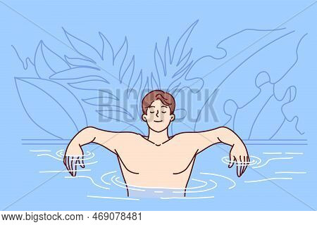 Carefree Man Is In Pool Near Leaves Of Tropical Plants, Arms Outstretched Leans On Skirting And Clos