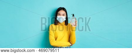 Covid-19, Social Distancing And Pandemic Concept. Cheerful Asian Woman Showing Hand Sanitizer, Recom