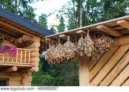 Outdoors View Of Logs Sauna With Brooms For Steam Bath
