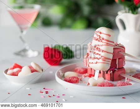 Decorated Valentines Day Cakesicles On A Plate With Candy And Sprinkles.