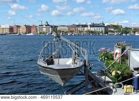 A Small Boat In A River With A City In The Background