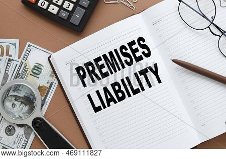 Premises Liability Text On An Open Notepad. Next To Dollar Bills