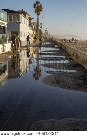People Moving On The Side Of Mission Beach Broadwalk Flooded And Covered With Sand After Being Hit W