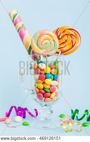 Colorful Candies In Cup On Table On Light Background Background. Large Swirled Lollipops. Creative C
