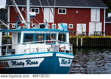 Whiteway Newfoundland Canada, September 25 2022: A Fishing Boat Moored At A Dock With A Rustic Tackl