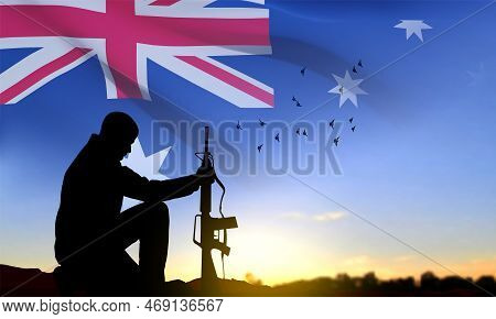 Silhouette Of Soldier Kneeling Down With Australian Flag On Background Of Sunset. Concept - Armed Fo