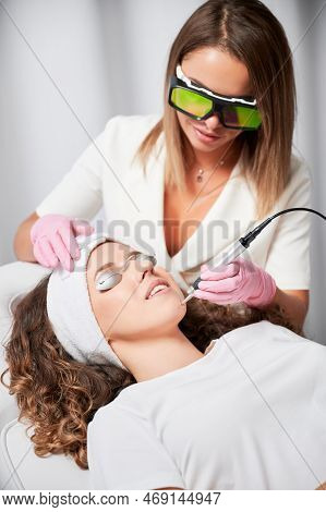 Woman Patient With Protection For Eyes Who Undergoing Laser Treatment Of Facial Vessels In Beauty Sa
