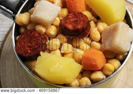 Cooked (cocido, Guiso) Stew, Chickpeas With Chorizo, Bacon, Carrot And Potato In A Green Saucepan An