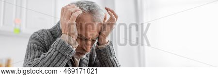 Senior Man Suffering From Azheimers Disease And Headache While Holding Hands Near Head, Banner.