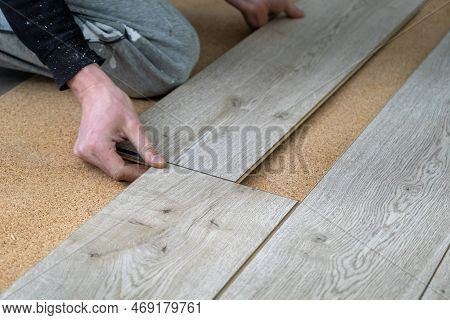 A Man Lays A Laminate Floor. Repair In The Apartment. Laminate Floor Professionally Installed.