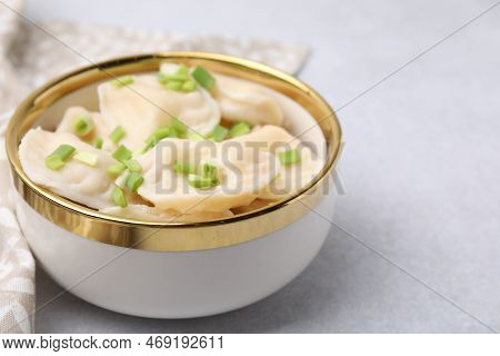 Cooked Dumplings (varenyky) With Tasty Filling And Green Onion On Light Table, Closeup