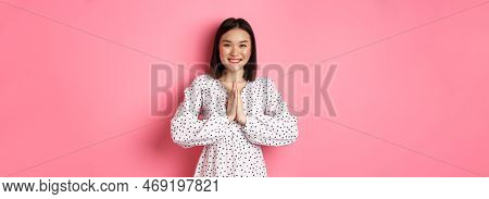 Beautiful Asian Woman Thanking You, Holding Hands Together In Appreciation Gesture, Smiling Happy At