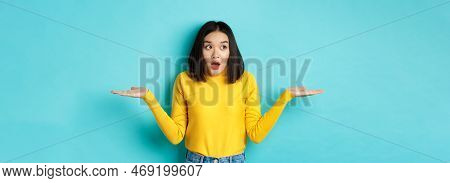Confused And Shocked Asian Woman Dont Understand, Shrugging With Spread Hands, Gasping And Looking L