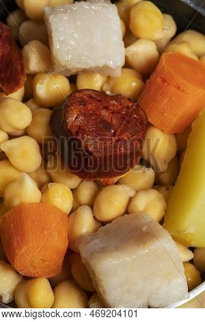 Cooked (cocido, Guiso) Stew, Chickpeas With Chorizo, Bacon, Carrot And Potato In A Green Saucepan. C