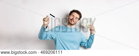 Carefree Male Model Dancing With Money And Credit Card, Smiling And Dreaming Of Shopping, Standing O