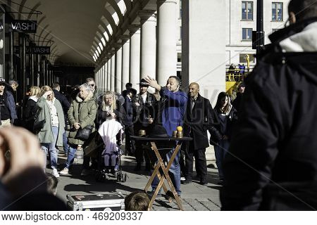 London - 02 27 2022: Street Performer Magician In Covent Garden With People Around