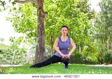 Motion kvinde udspænding forstrækning benmusklerne under udendørs kører workout. Smile happy sport 