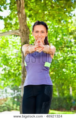 Smuk kvinde udøvelsen yoga i parken.