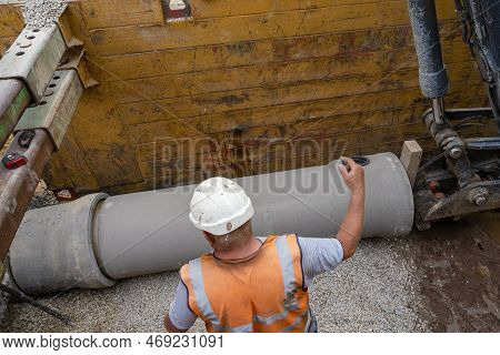 Builder Installing Big Diameter Concrete Drainage Pipe Protected By Trench Support System During Dee