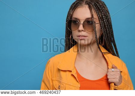 Beautiful Woman With Long African Braids And Sunglasses On Blue Background, Space For Text