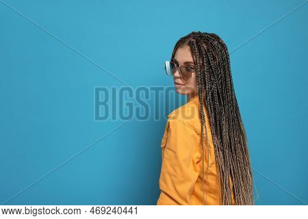 Beautiful Woman With Long African Braids And Sunglasses On Blue Background, Space For Text