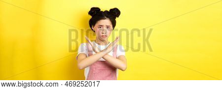 Sad Girl Begging To Stop, Frowning Uspet And Showing Cross Sign, Say No, Standing Gloomy On Yellow B