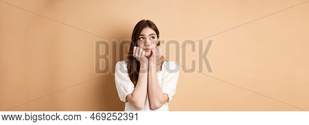 Dreamy Cute Woman Looking Pensive At Upper Left Corner, Thinking Of Something Romantic, Standing On 