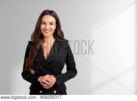 Smiling Attractive Businesswoman Wearing Formal Wear Standing Holding Hands Together Near Empty Whit