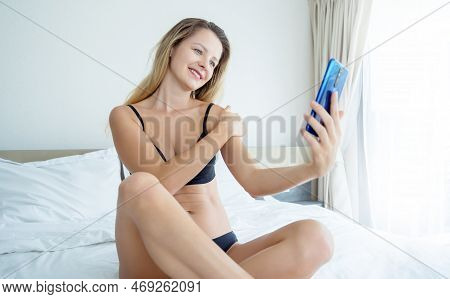 Young Sexy Woman Posing In Front Of Smartphone In His Hand And Working As Webcam Model