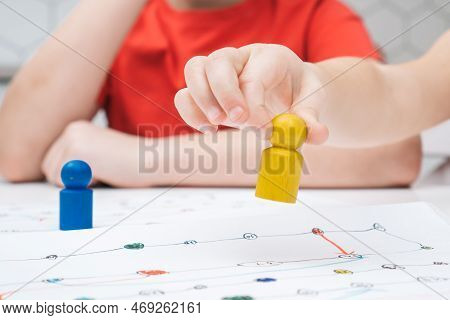 Cropped Photo Of Group Of Children Sitting At Table, Playing Tabletop Game, Holding Bright Yellow Fi
