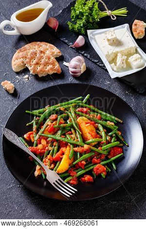 Fasolakia Lathera, Green Beans, Onion And Potatoes Stewed In Tomato, Herbs And Olive Oil On Black Pl
