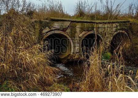 Small Streamlet Runs Through A Stone Pipe