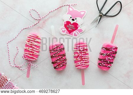 Homemade Valentine Cakesicle Treats With A Valentine Card Attached To One.