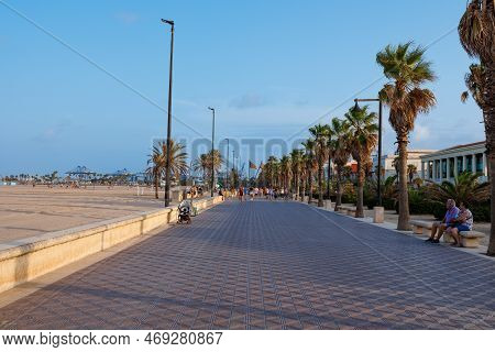 Valencia, Spain - July 2022: Pedestrian Path With People And Palm Trees Along Platja De Cabanyal Bea