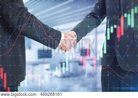 Close Up Of Businessmen Shaking Hands With Glowing Forex Chart On Blurry Office Interior Background.