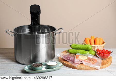 Thermal Immersion Circulator In Pot And Ingredients On White Wooden Table. Vacuum Packing For Sous V
