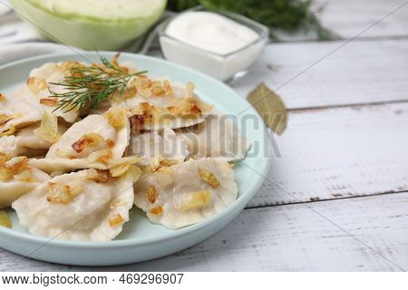 Cooked Dumplings (varenyky) With Tasty Filling, Fried Onions And Dill On Wooden Table, Closeup