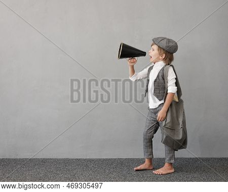 Newsboy Shouting Against Grunge Wall Background. Boy Selling Newspaper